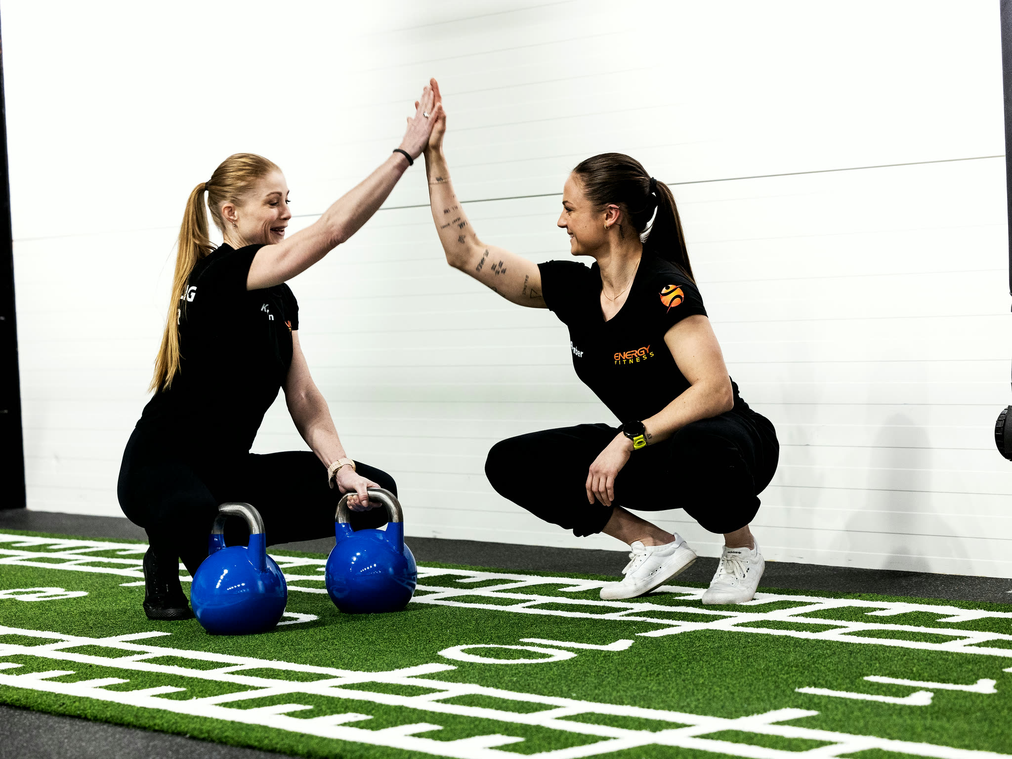 To som gir hverandre en high five etter en økt hos ENERGY Fitness