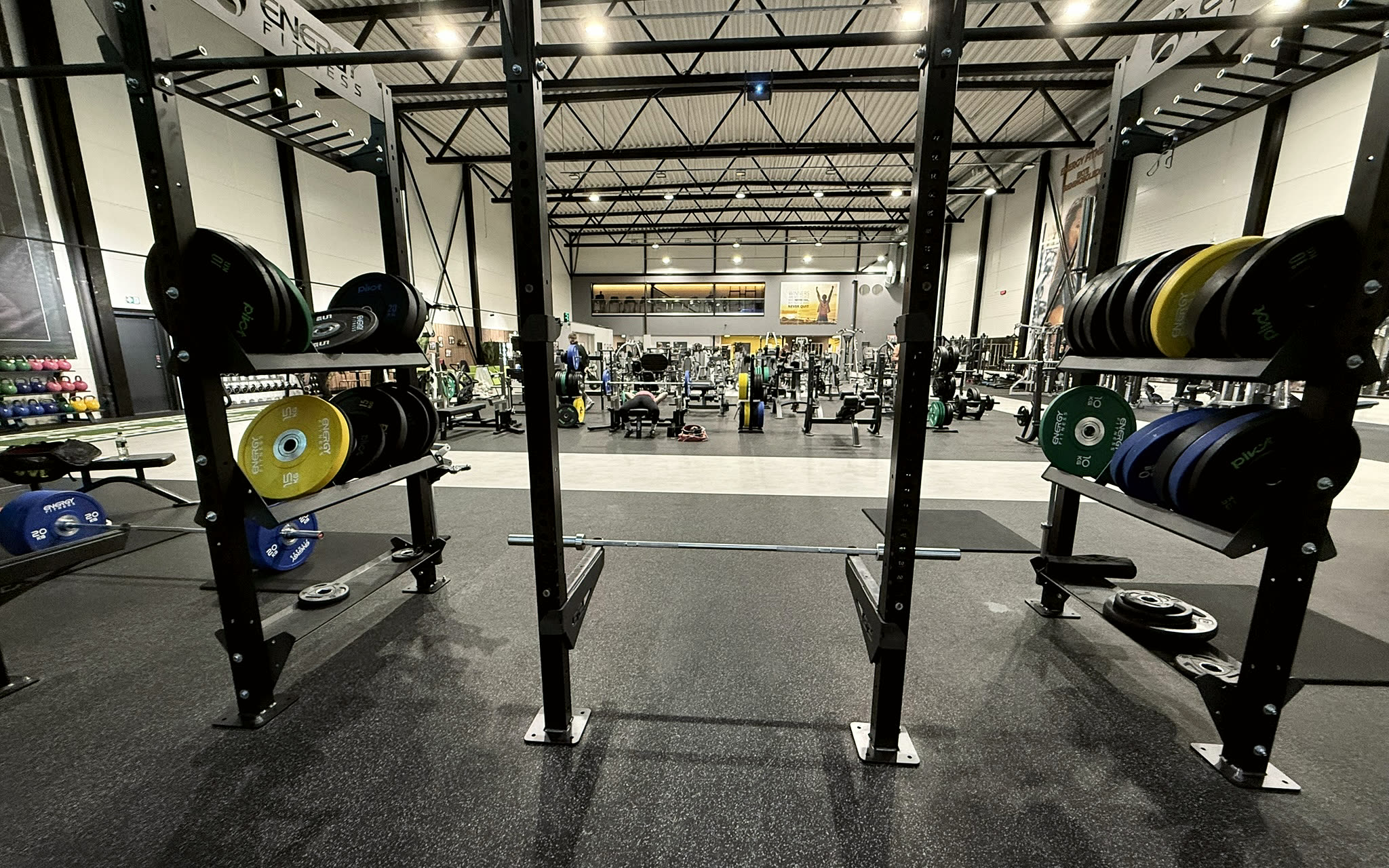 Treningshallen hos ENERGY Fitness, sett fra et rack med vektskiver i forgrunnen