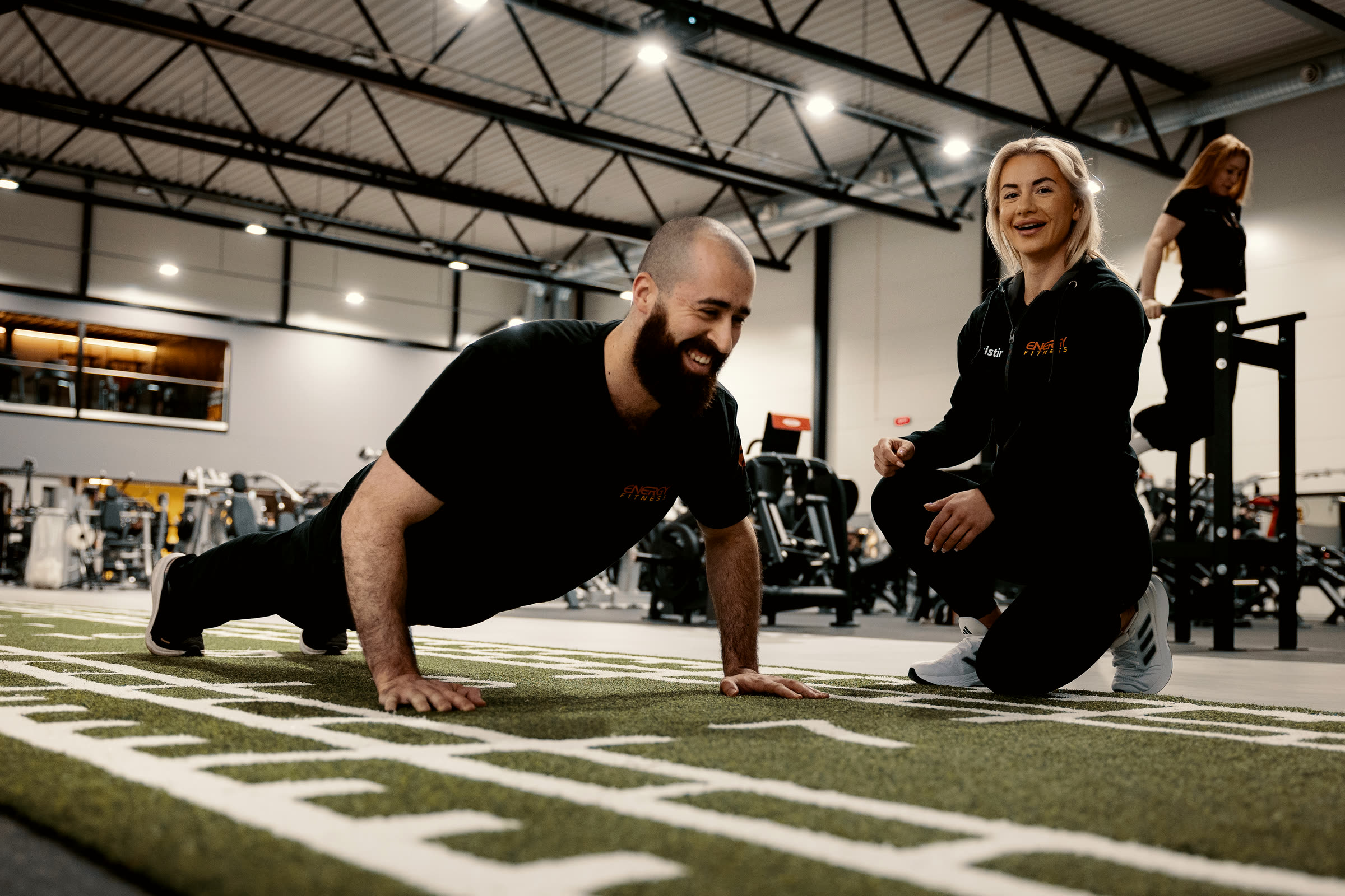 Personlig trener veileder et medlem gjennom en push-up hos ENERGY Fitness